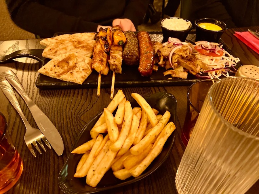 Side serving of crispy, seasoned French Fries/chips served on a black plate at 
Greek Theory, Falkirk 